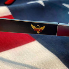 Load image into Gallery viewer, Close-up of sunglasses frame showing full logo of Semper Fly Eagle with Semper Fly text.  An American flag is the background image
